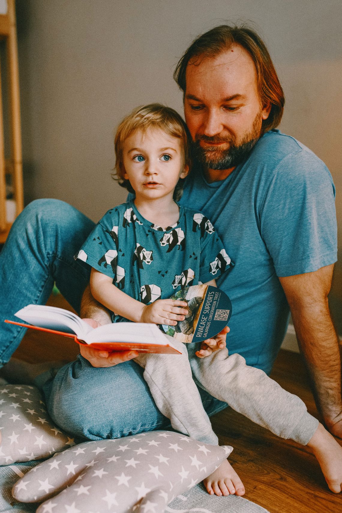 Father reading a book with his young child during a warm family learning moment
