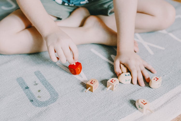 Child Playing With White And Red Lego Blocks