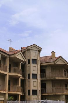 Exterior view of a Mediterranean style apartment building with balconies, highlighting the architecture.