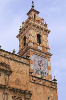 A detailed view of an ancient clock tower featuring intricate architecture against a clear blue sky.