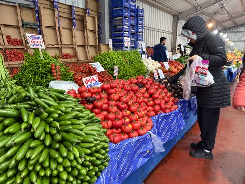 Free Customers shop for fresh produce at an Istanbul market featuring tomatoes, cucumbers, and more. Stock Photo