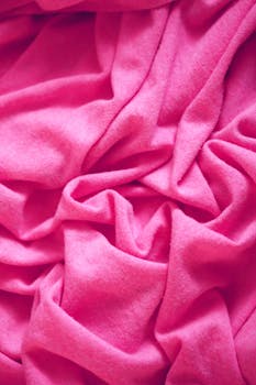 特写镜头展示了柔软、皱巴巴的粉红色面料的质感与柔软度