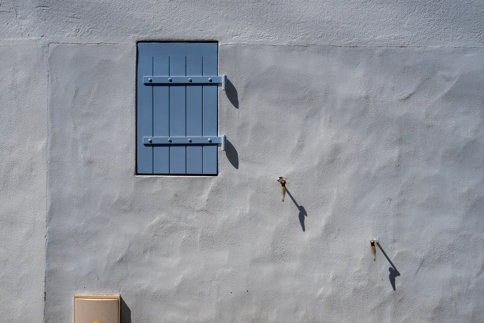 Minimal blue window on a plastered wall
