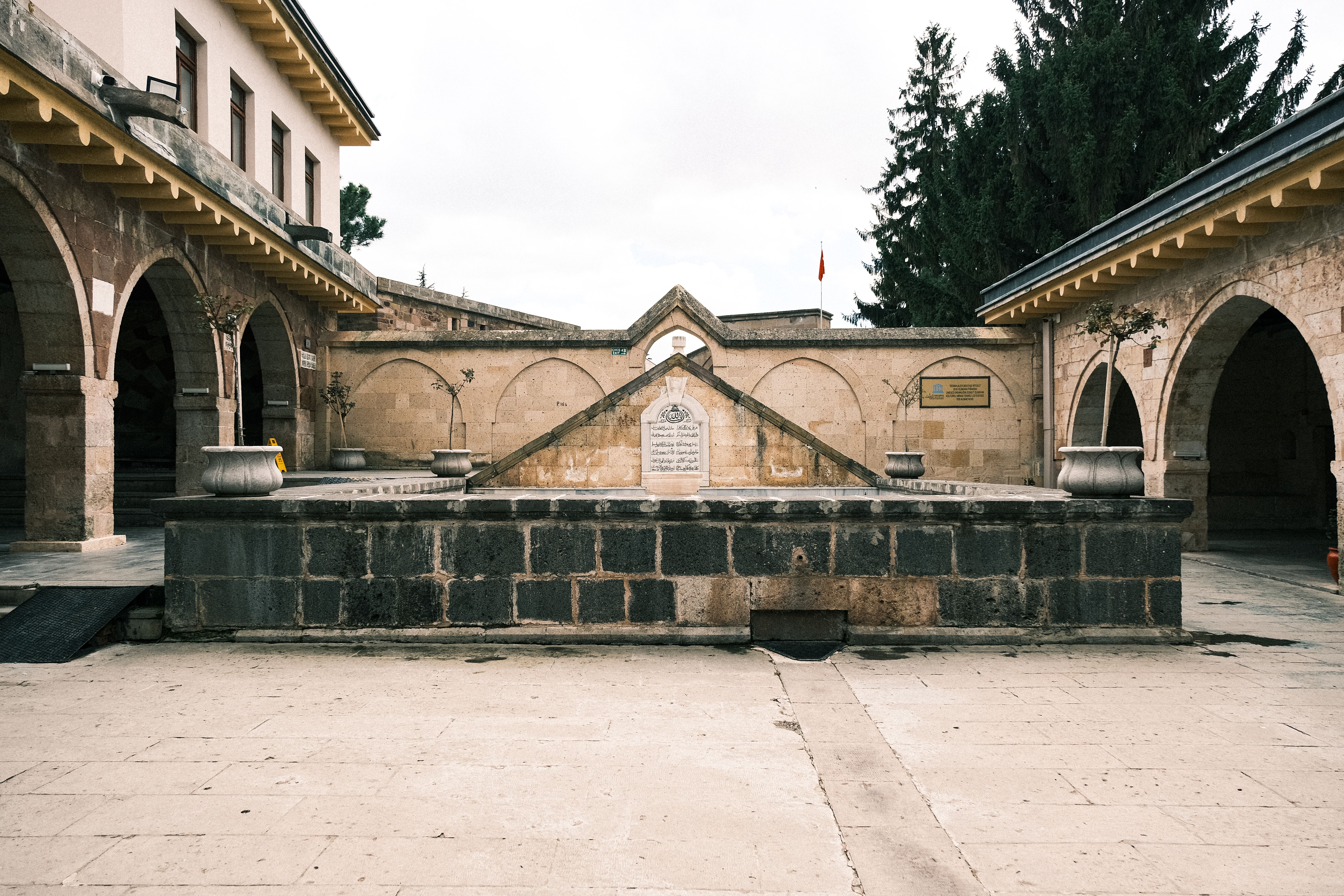 A tranquil historic courtyard featuring stone arches and architectural details.