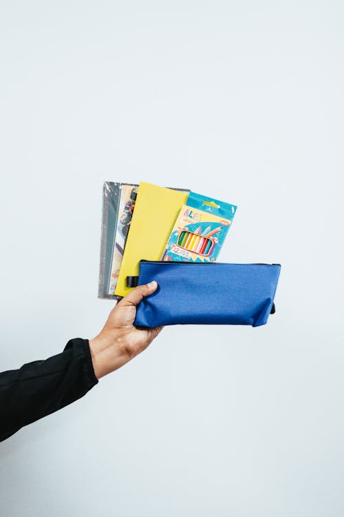 Person Holding Blue Pouch And Colored Pencils