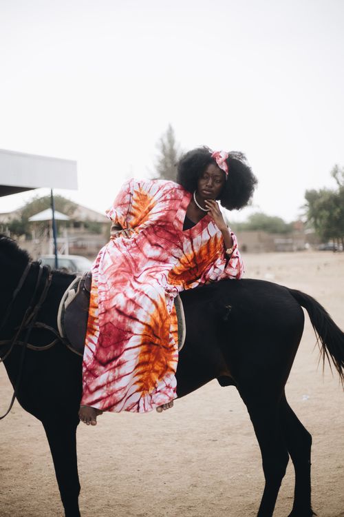 Free A woman in traditional attire sits on a horse outdoors, showcasing Nigerian culture. Stock Photo