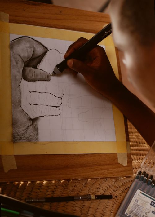 Free Close-up of an artist sketching a hand on paper using a charcoal pencil, showcasing detailed artistry. Stock Photo