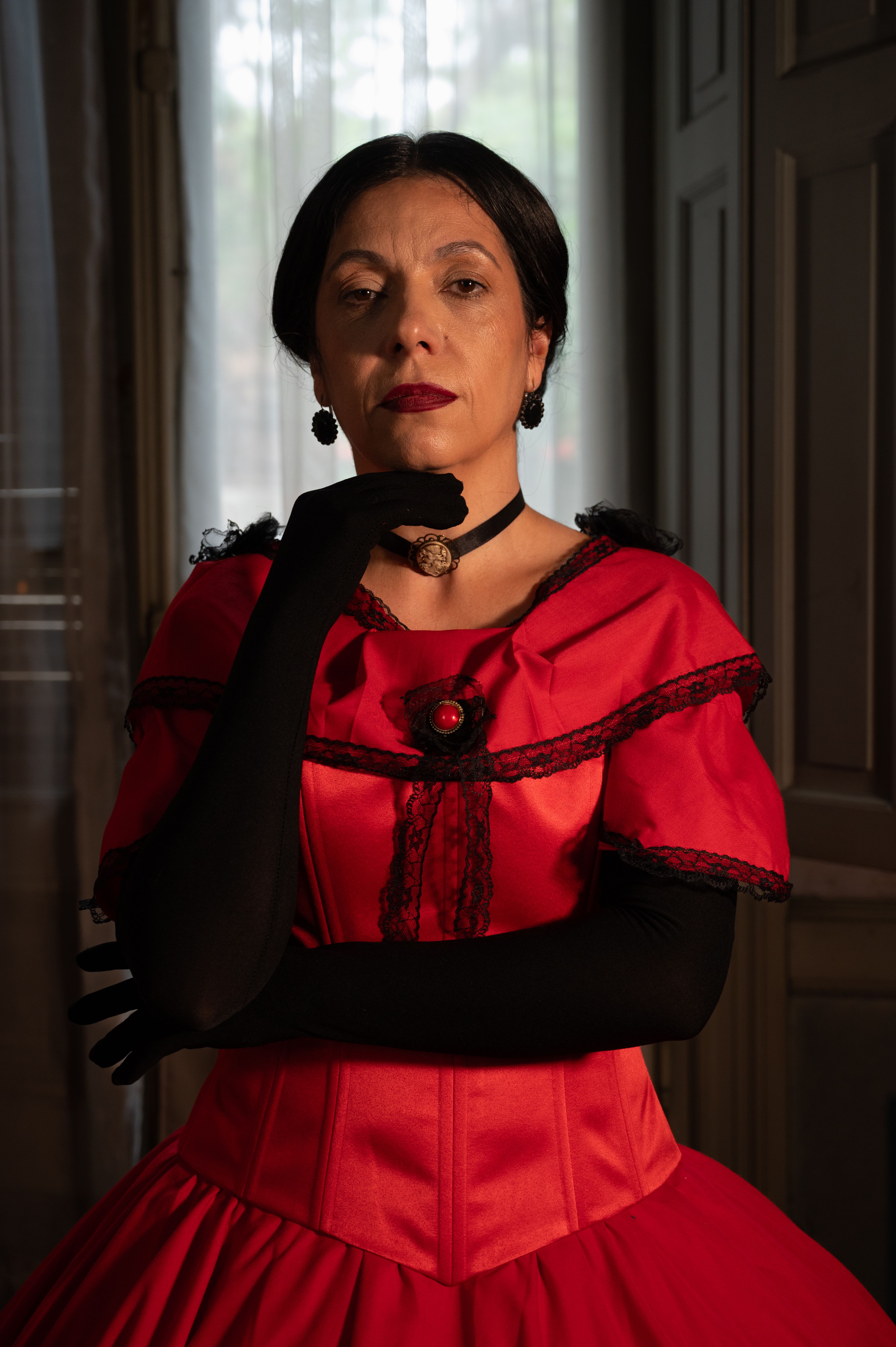Portrait of a woman in a Victorian-style outfit with dramatic lighting.