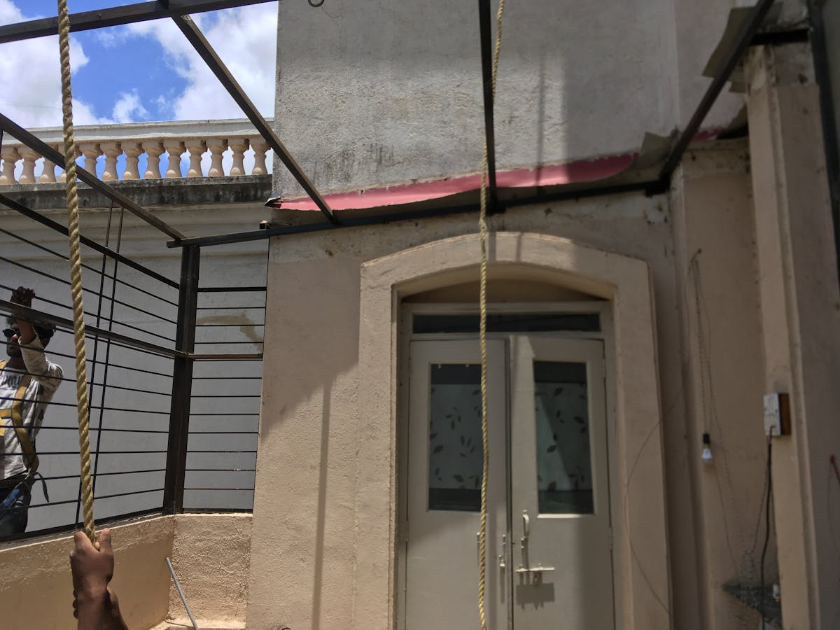 Green smoothie drink in a glass with leafy greens and fruits around it