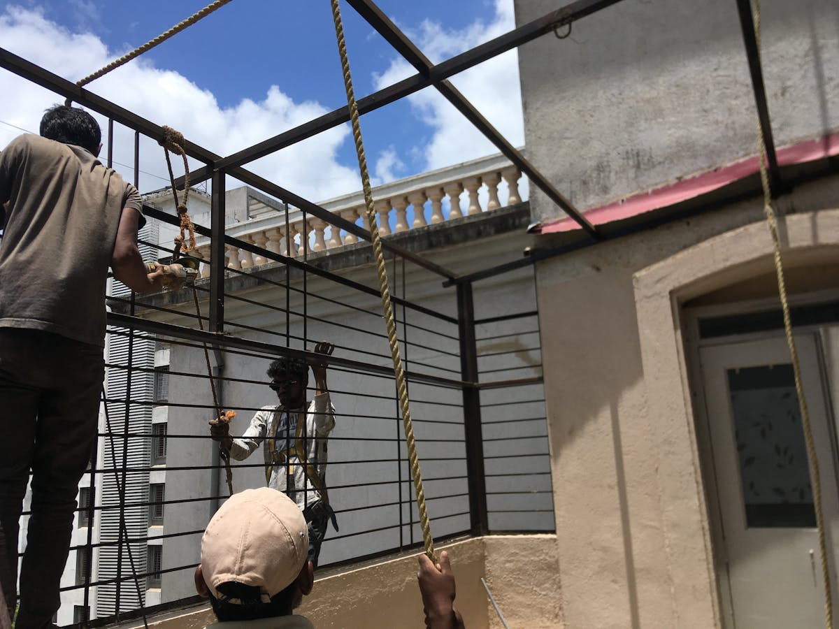 Hands assembling a breakfast bowl with yogurt-like base and fruit and nut toppings
