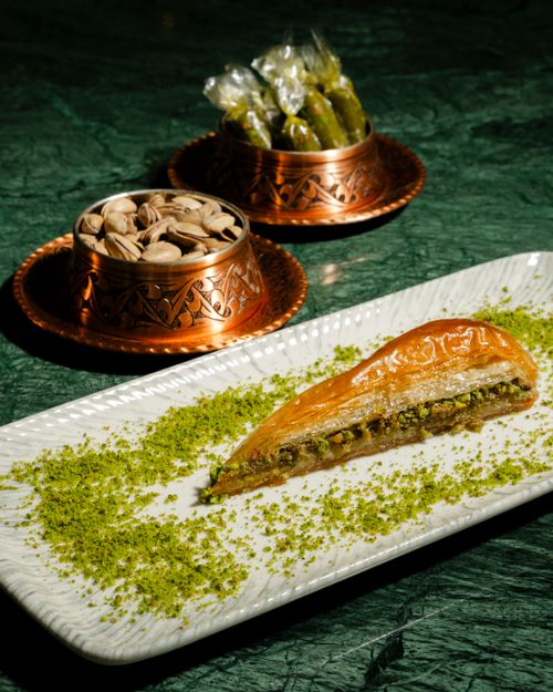 Free Delicious baklava garnished with pistachios, served elegantly on a plate, showcasing Gaziantep's culinary heritage. Stock Photo