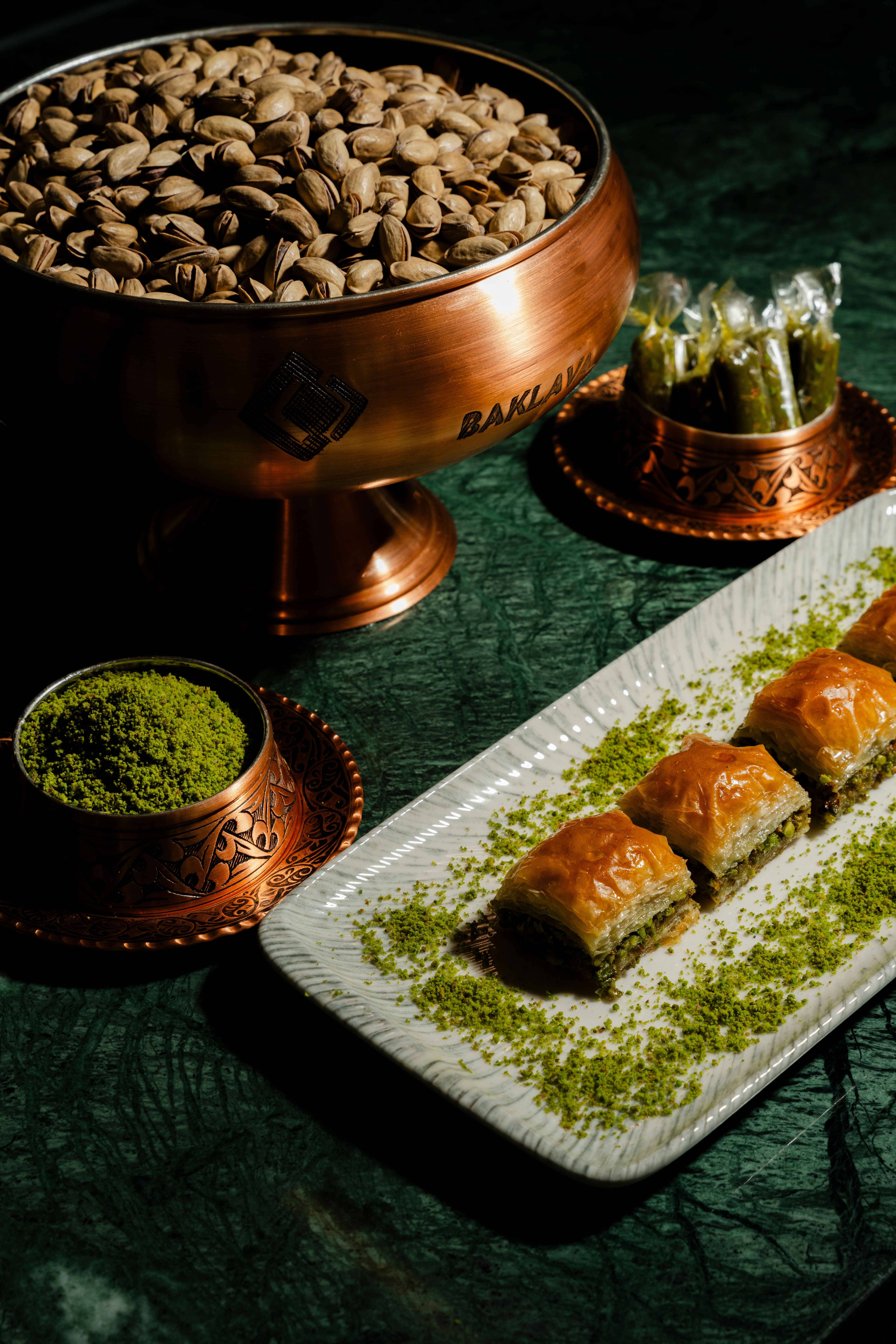 Baklava und Pistazien auf dunkelgrünem Marmor