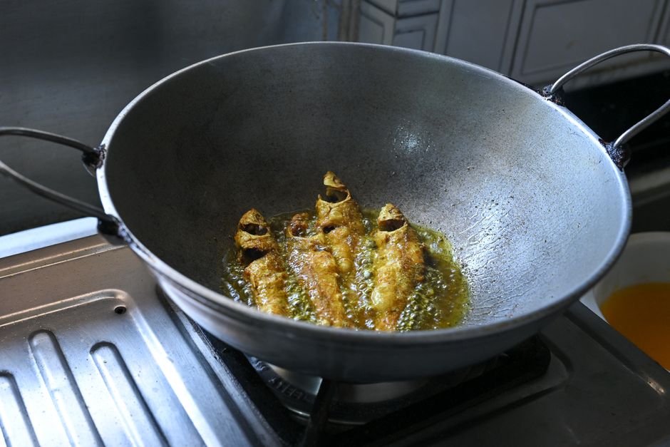 Crispy fish frying in an iron kadhai, showcasing authentic homemade Indian cooking.