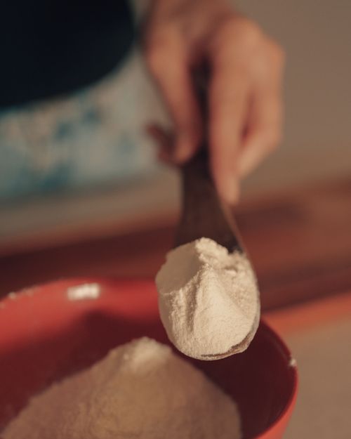 Free Close-up of flour being scooped into a red bowl, perfect for baking scenes. Stock Photo