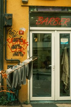 Colorful barber shop entrance with graffiti and towels in a lively İstanbul street scene.