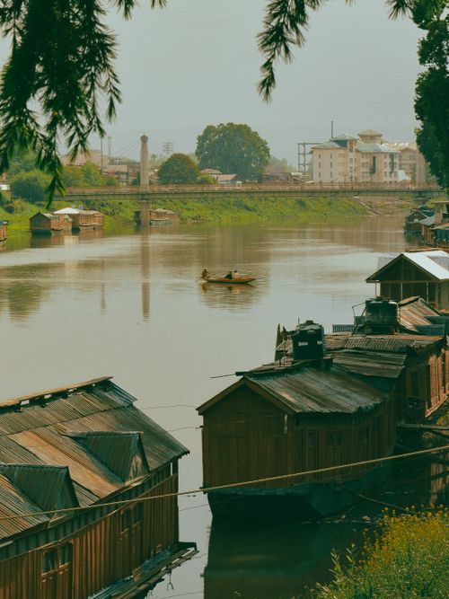 Free A serene scene of houseboats on Dal Lake with a lone boat in Srinagar, India. Stock Photo