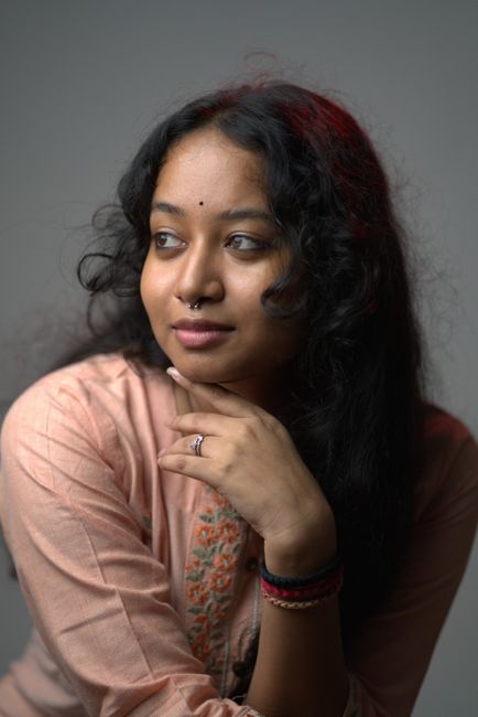 Portrait of a thoughtful young Indian woman in traditional attire, looking away gracefully.