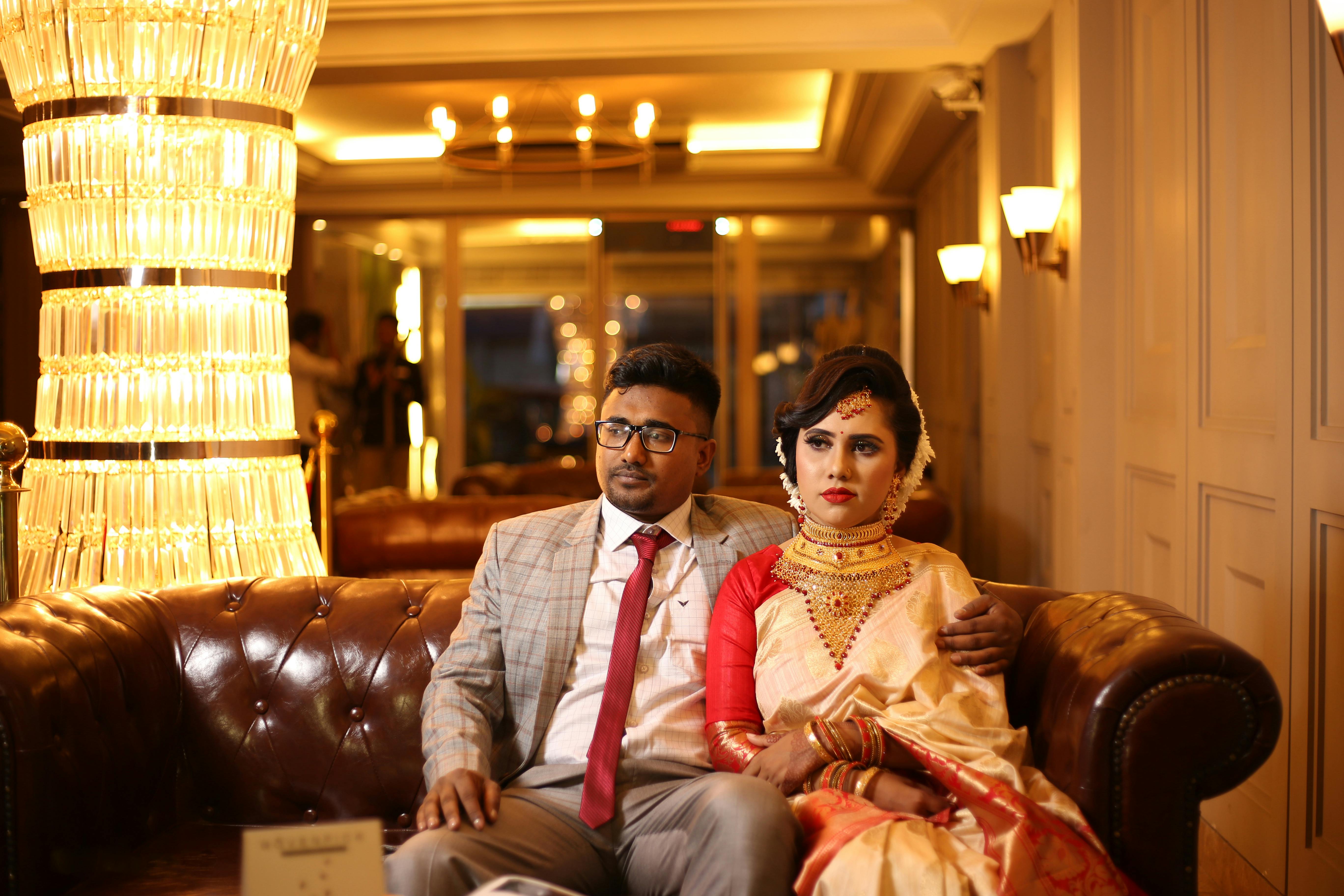 Man in Suit Sitting Beside Woman in Sari