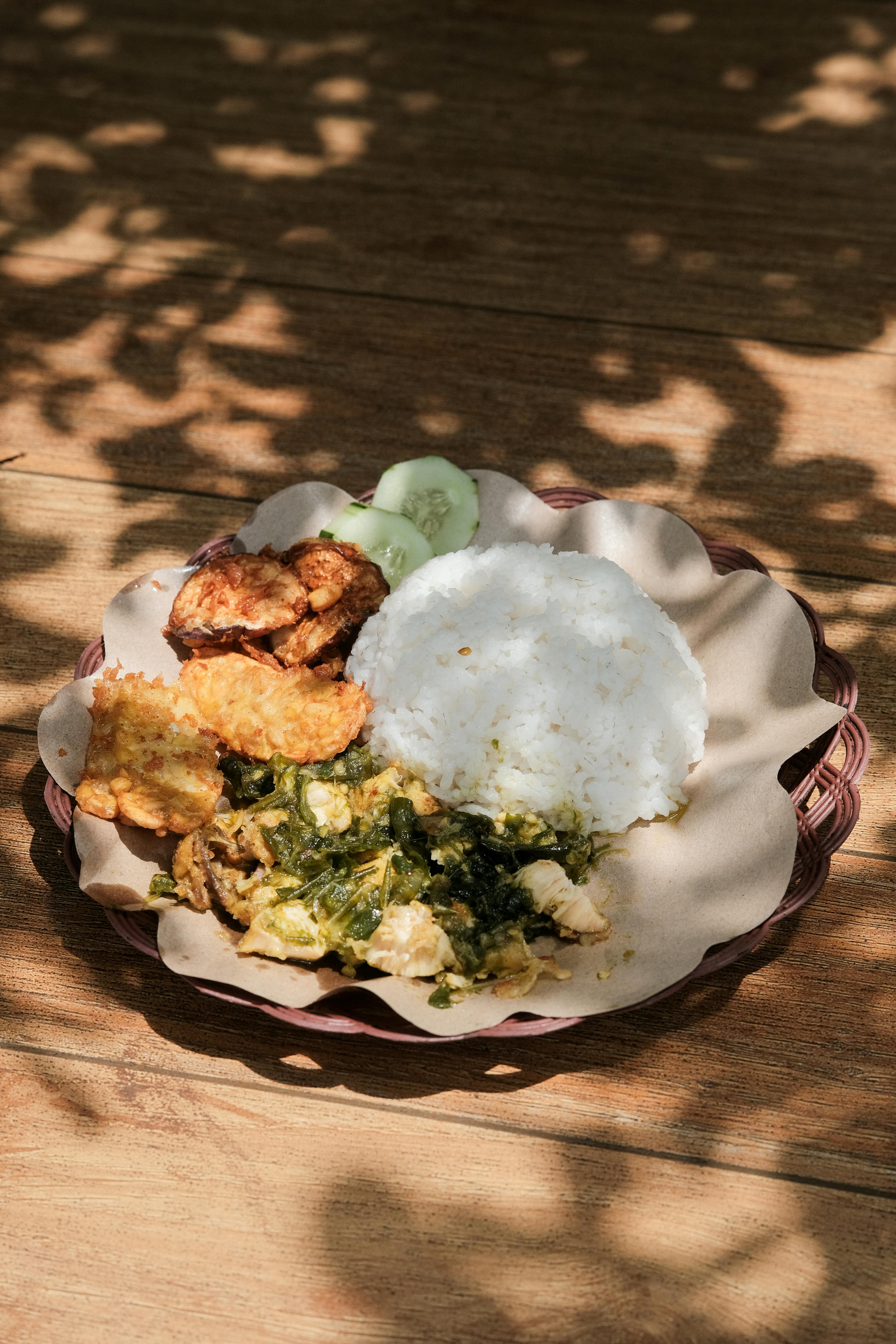 Delicious Indonesian smashed chicken with rice and side dishes, perfect for food enthusiasts.