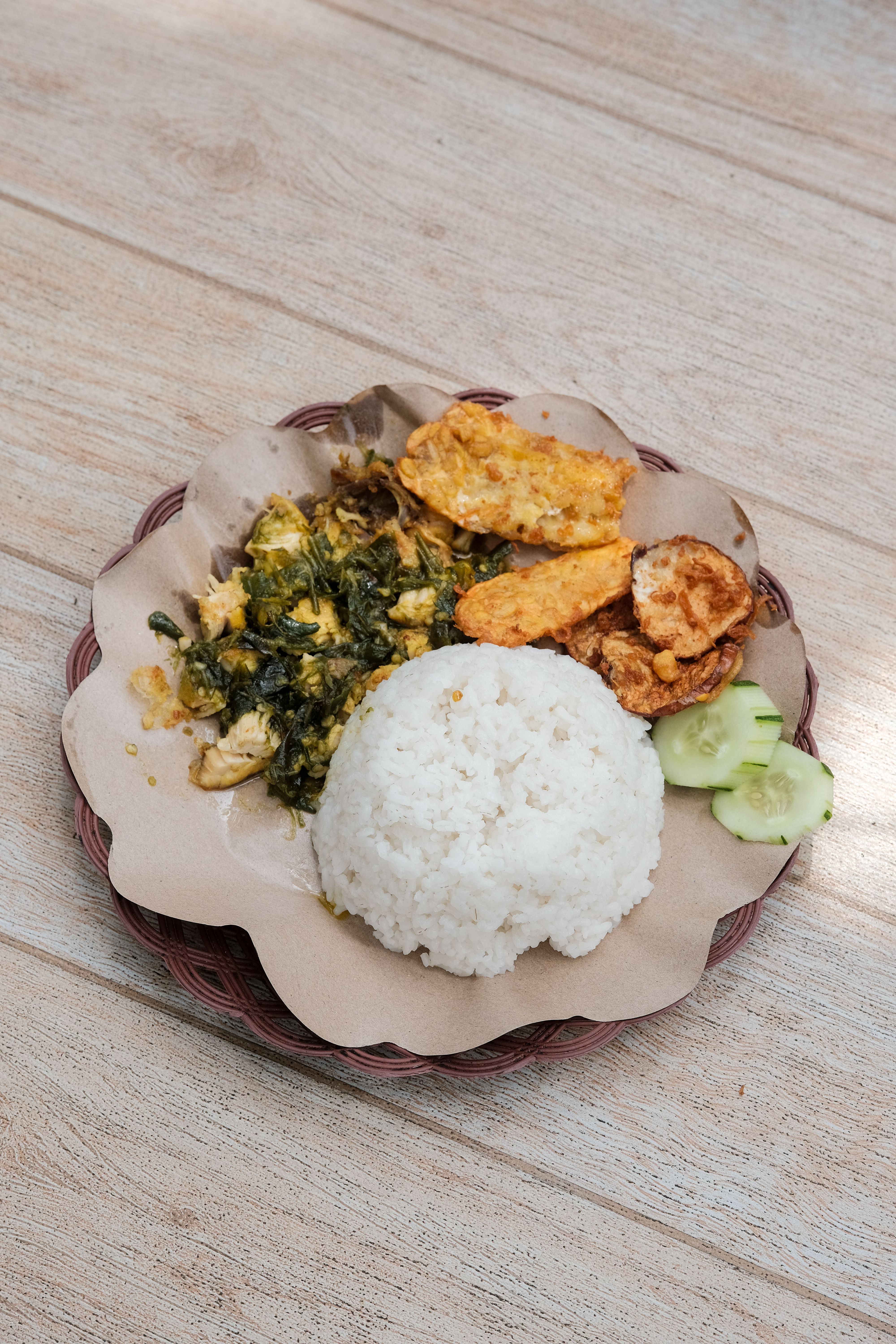Authentic Indonesian nasi campur with rice, vegetables, and sides. A tantalizing culinary delight from Indonesia.