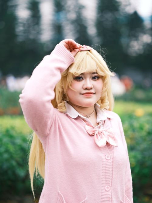 Free A captivating cosplay portrait of a young woman in a pink outfit taken outdoors in a Vietnamese garden. Stock Photo