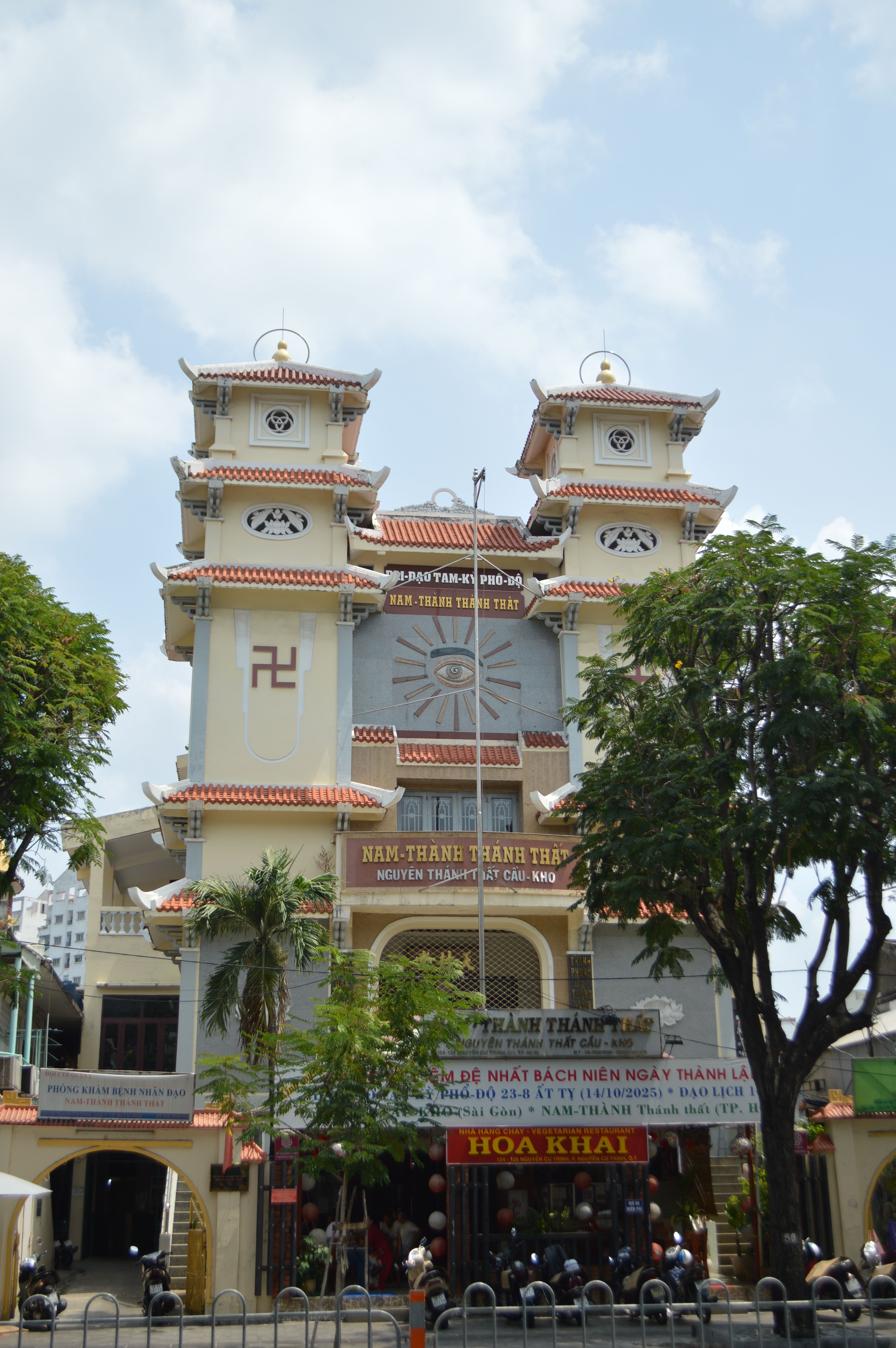 A Cao Dai temple showcasing unique architecture and cultural significance in a lively urban setting.