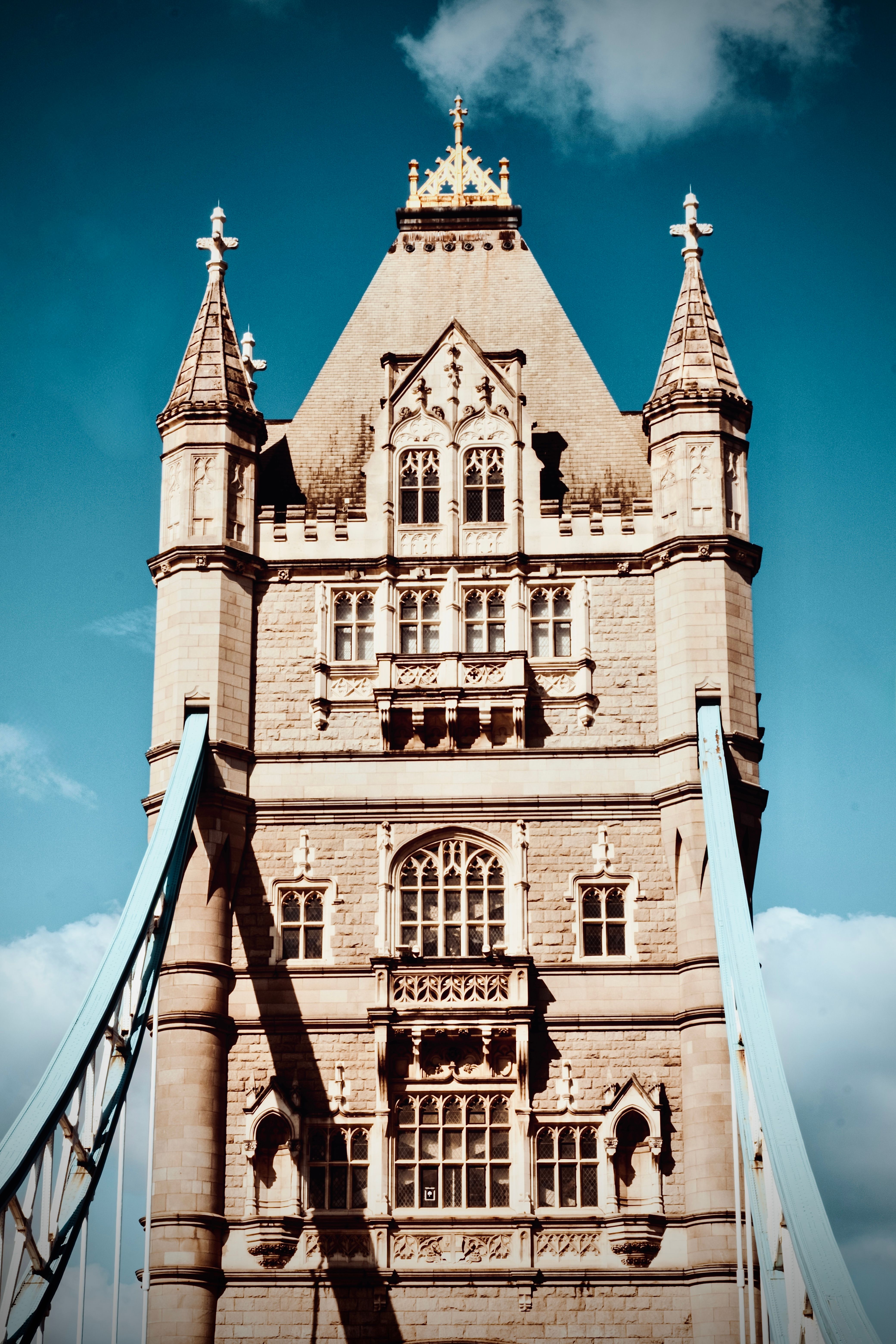 Intricate architectural details of Tower Bridge in London against a blue sky.
