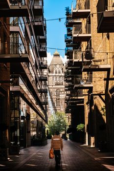 Sunlit alley in London with historic architecture and modern apartments.