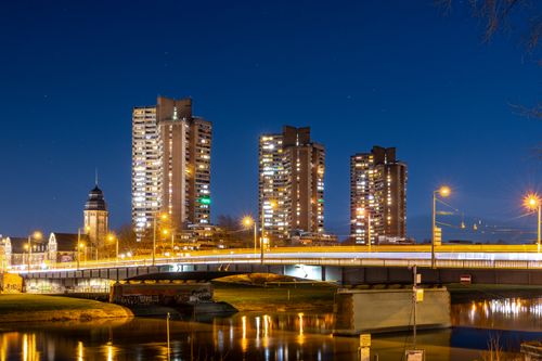 Free A stunning night view of a city with illuminated skyscrapers and a lit-up bridge. Stock Photo