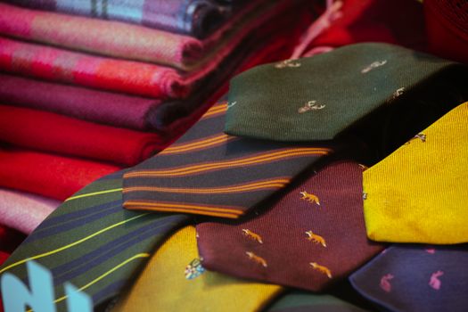 A vibrant display of patterned silk ties and colorful wool fabrics, perfect for men's fashion and textile lovers.