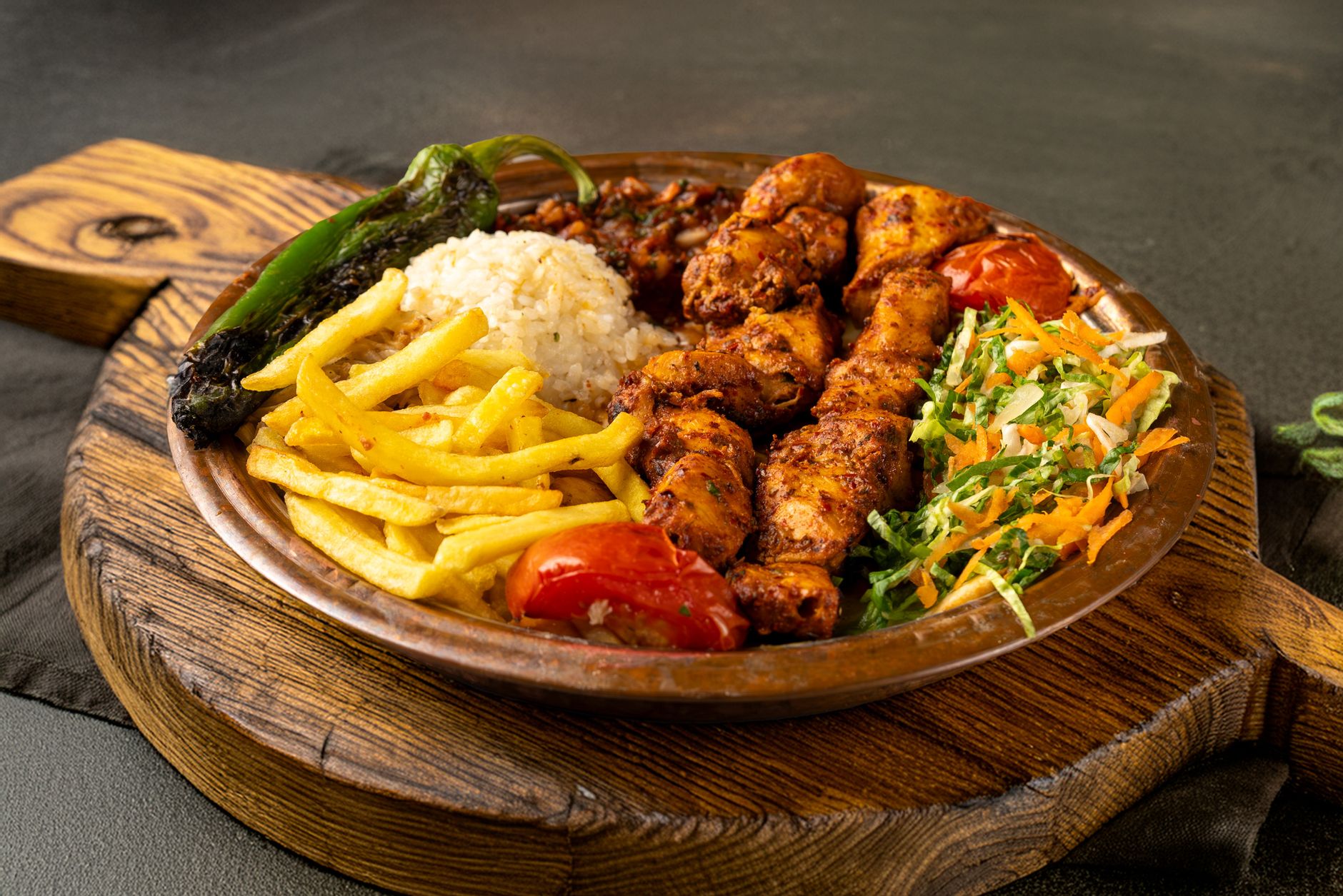 Brightly colored and perfectly grilled chicken with mixed vegetables on a wooden board