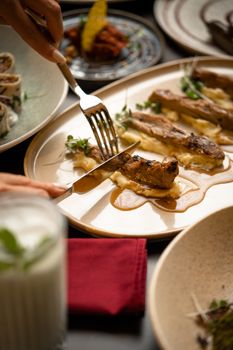 Close-up of a gourmet dish being prepared with fine dining presentation on a ceramic plate.