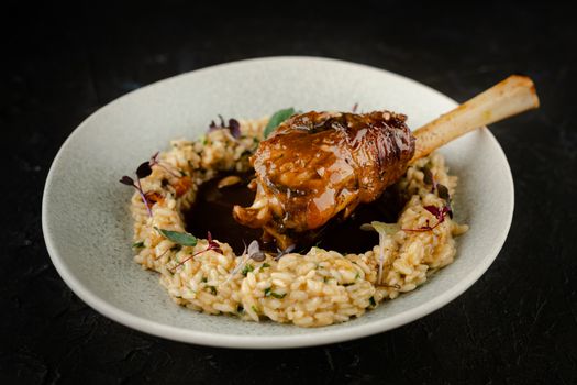 Delicious lamb shank served with creamy risotto, perfect for gourmet dining and food styling.
