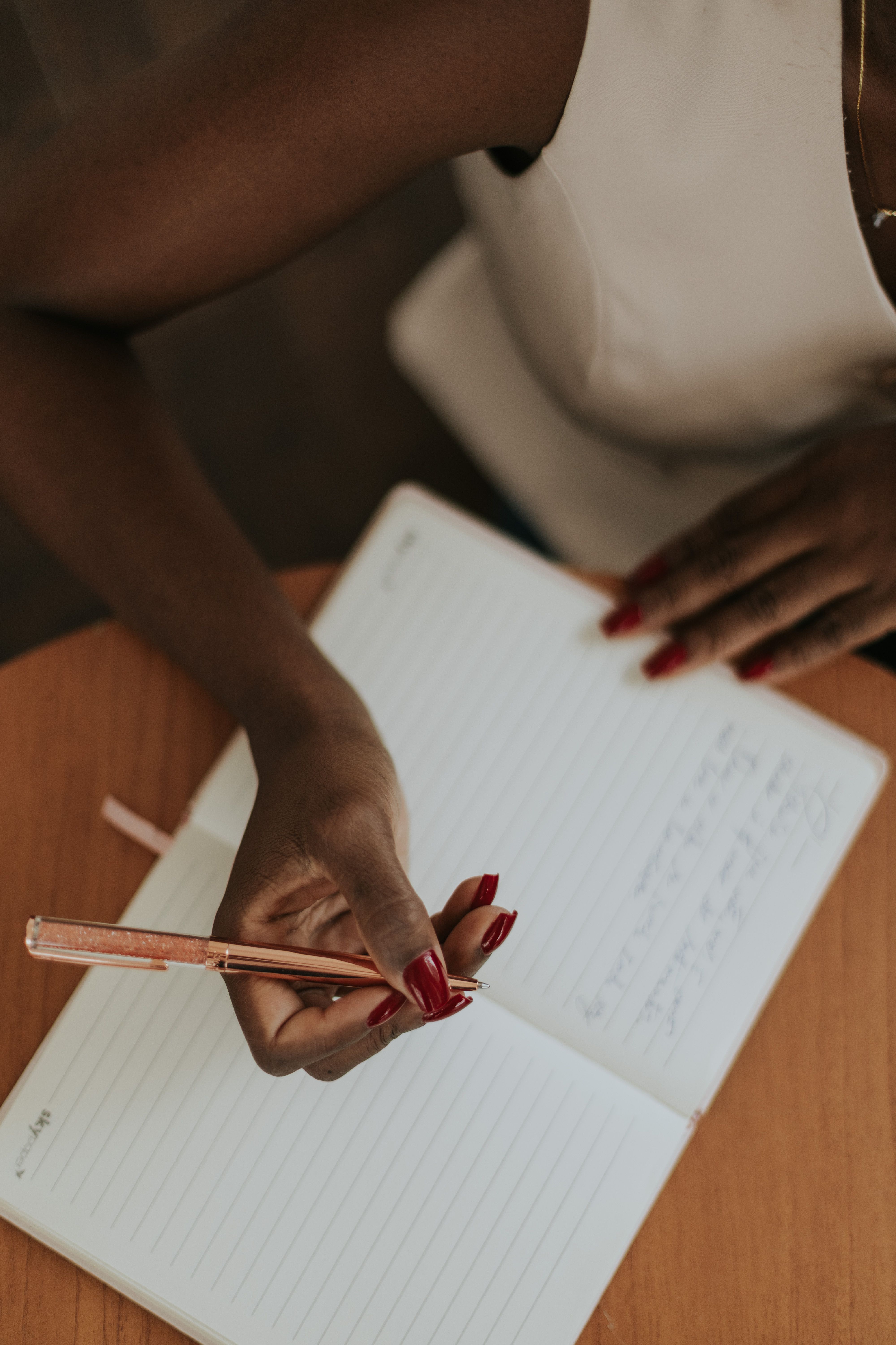 Person writing thoughtfully, working through difficult emotions
