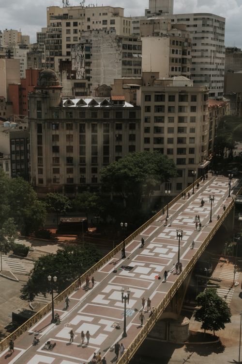 Free Street view of downtown São Paulo with pedestrians on patterned walkway, surrounded by skyscrapers. Stock Photo