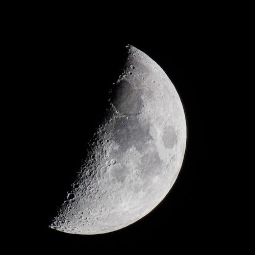 Free Detailed shot of the crescent moon with visible lunar craters and maria set against a dark night sky. Stock Photo