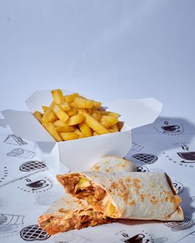 Tasty wrap with chicken filling paired with crispy fries in a white box, perfect for lunch or takeaway.