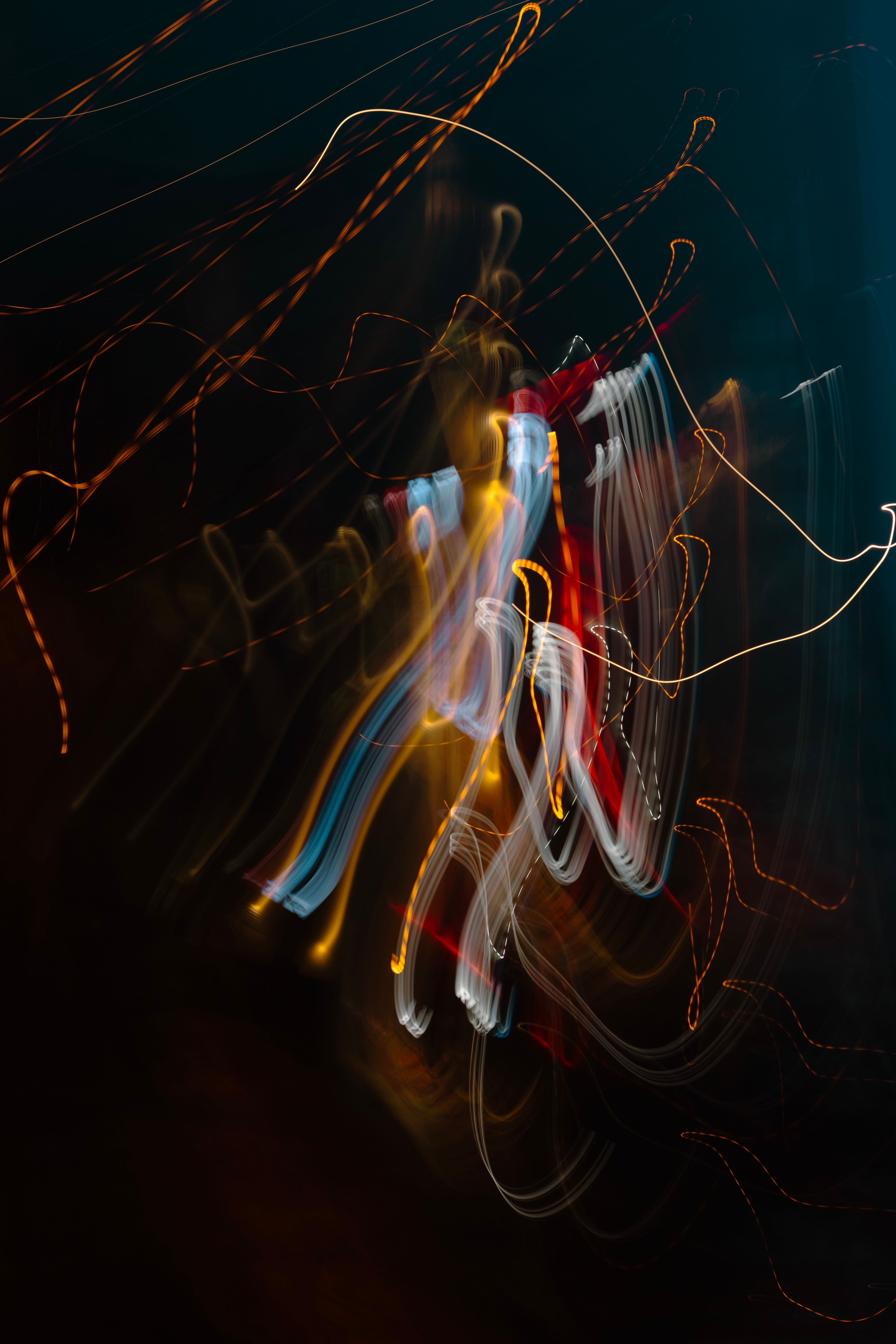 Colorful light streaks captured in a long exposure at night, showcasing abstract art through movement.