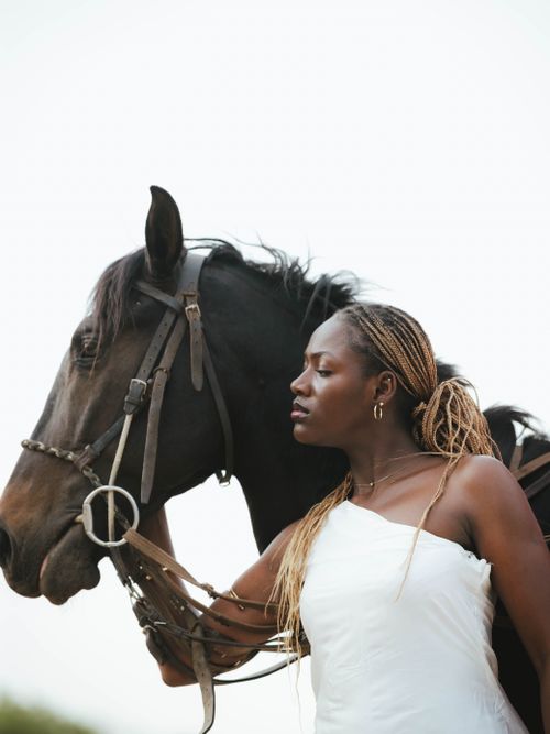 Free Elegant portrait of a woman lovingly embracing a horse outdoors, exuding calm and connection. Stock Photo