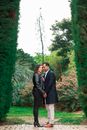 Couple Standing Between Tall Hedges