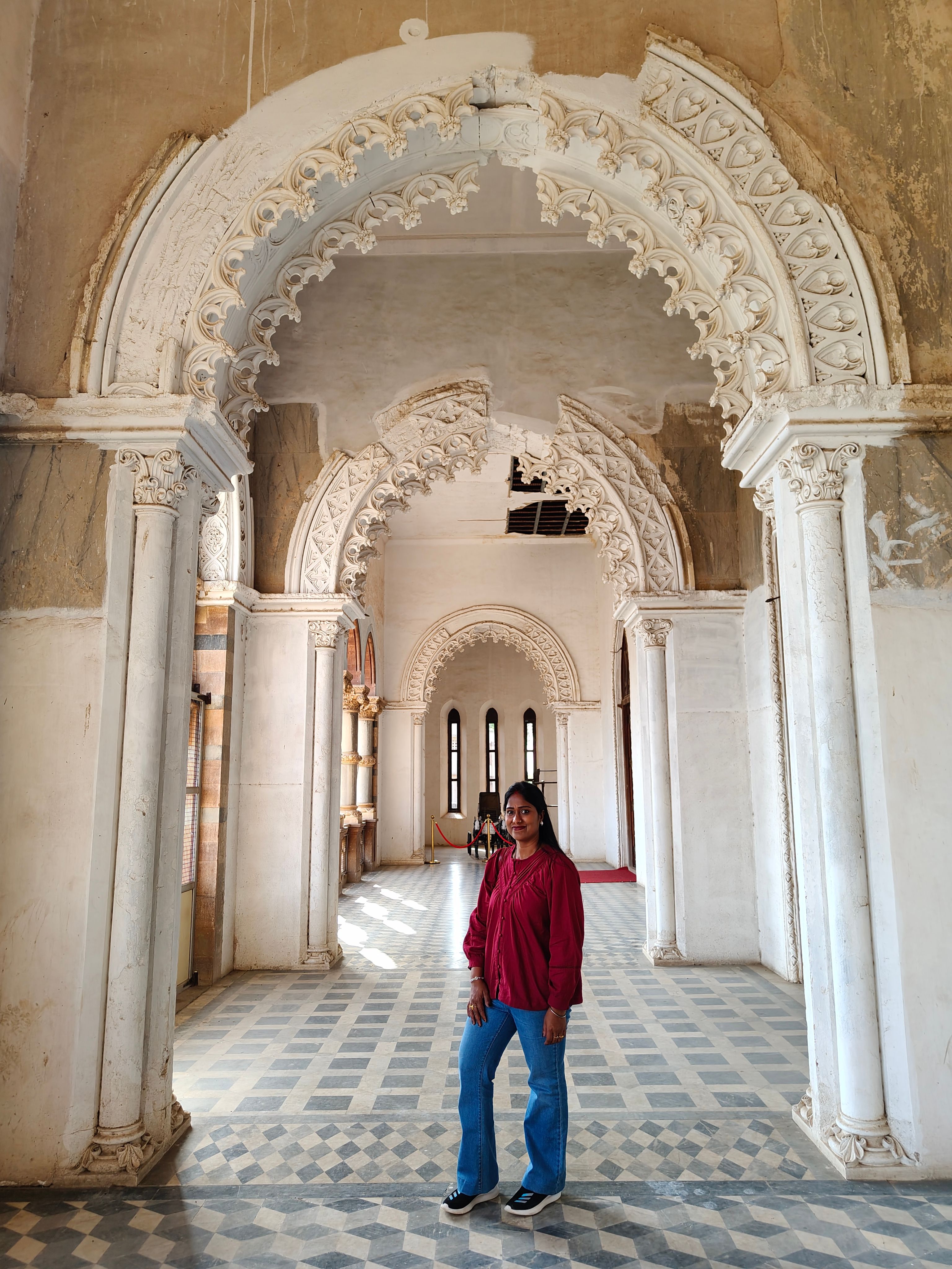 Explore the intricate arches and elegant design of a historic palace corridor in Gujarat, India.