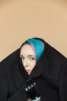 一位蓝发假肢女子的艺术肖像从一件宽大的西装外套中探出头来