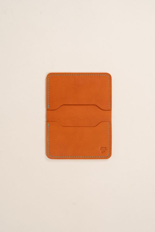 Free Minimalist leather wallet with stitch detailing on a plain backdrop. Stock Photo