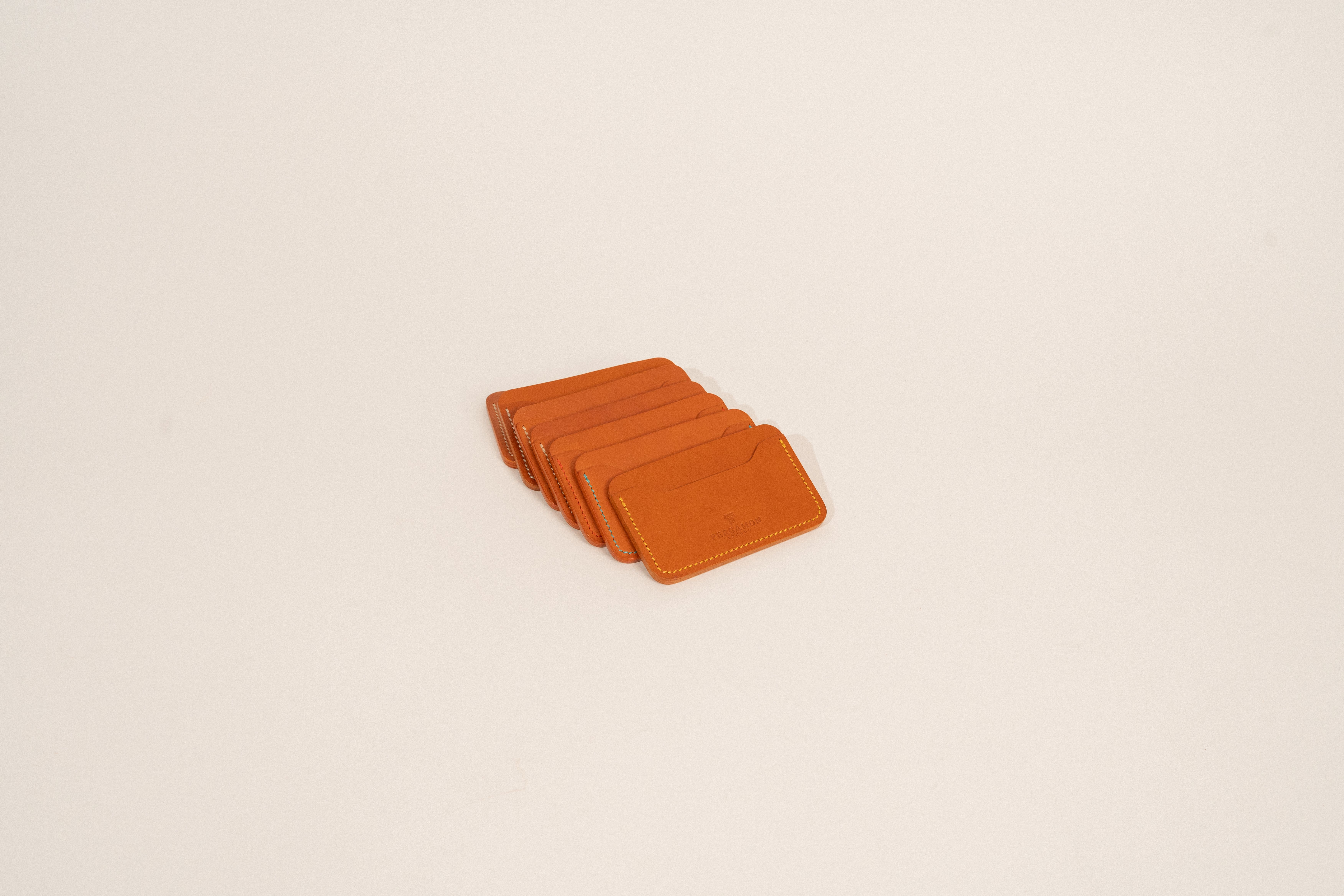Brown leather card holders displayed on a neutral background