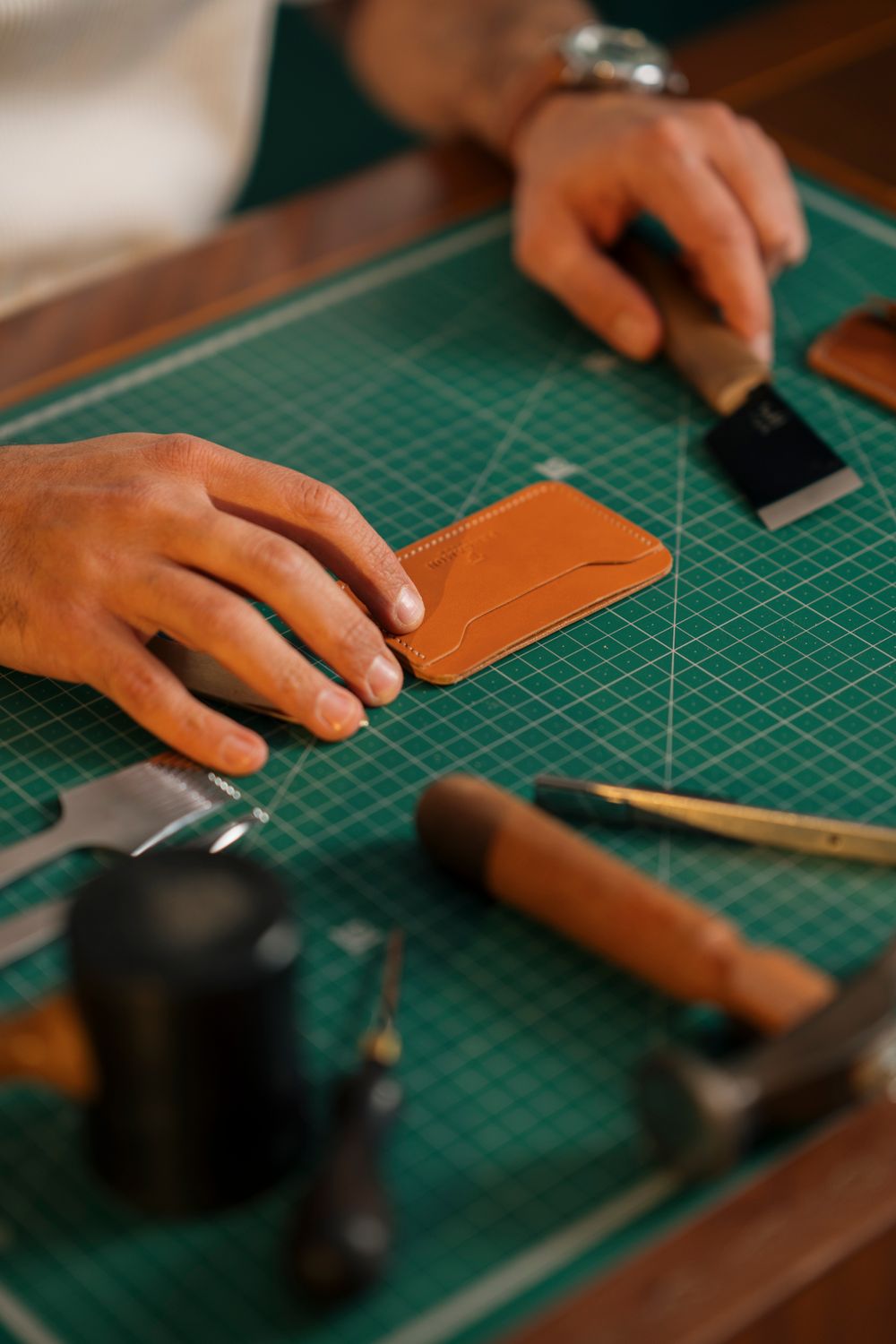 Repairing a leather piece by hand at the bench