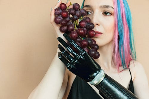 Woman in Black Tank Top Holding a Bunch of Grapes 