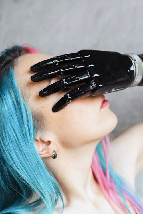 Woman with Colored Hair Covering Her face with Hand