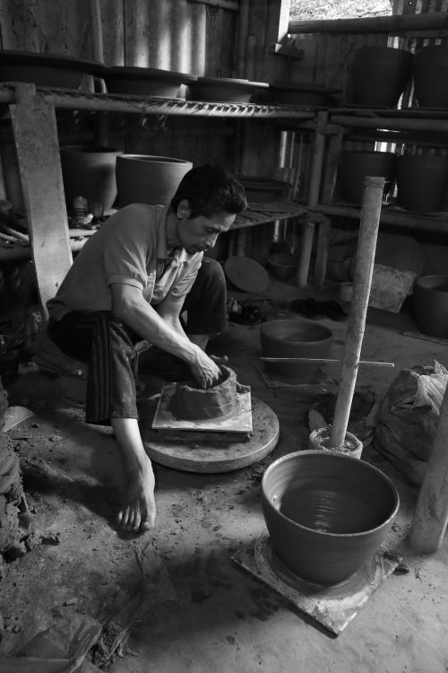 Free A potter crafts a clay pot in a rustic workshop, showcasing traditional pottery techniques. Stock Photo