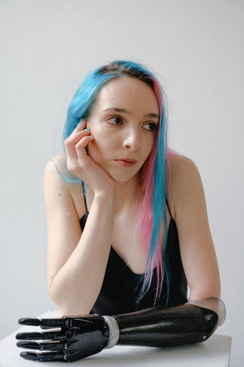 青とピンクの髪の黒いタンクトップの女性