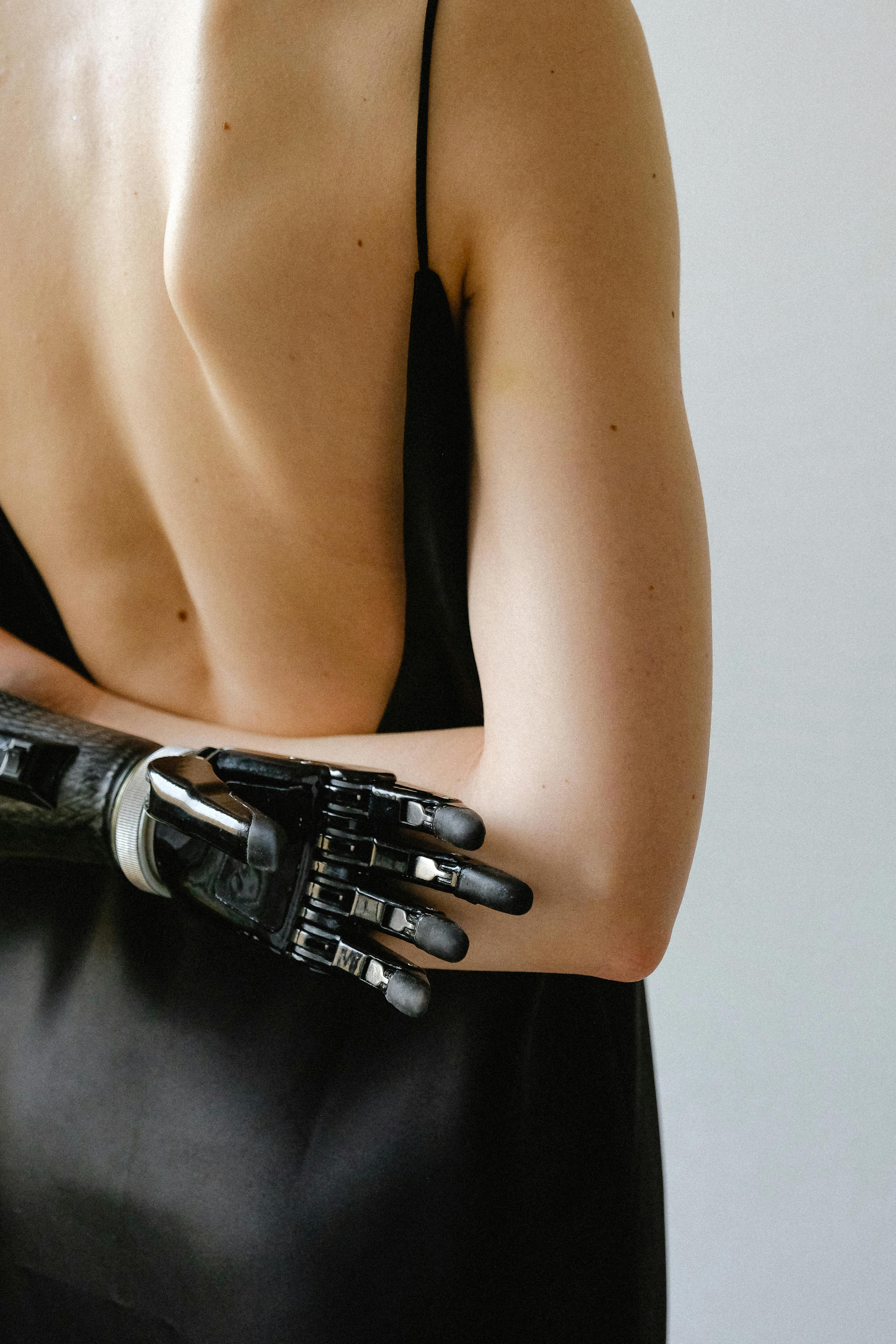 woman in black slip dress with arms crossed behind her back